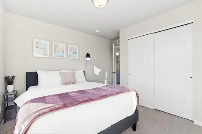 a bedroom with a large bed and a closet at Comet Haus Modern 3BR with Office and King Beds in Fort Collins
