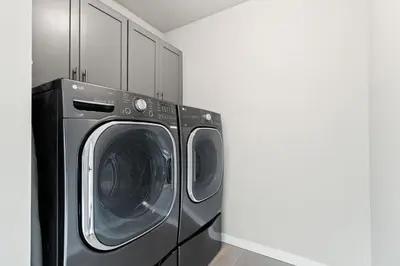 a laundry room with a washer and dryer at Comet Haus Modern 3BR with Office and King Beds in Fort Collins
