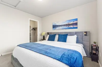 a bedroom with a large bed with blue pillows at Comet Haus Modern 3BR with Office and King Beds in Fort Collins