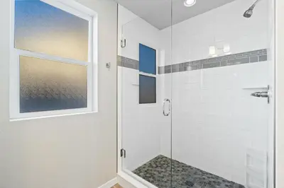 a bathroom with a shower with a glass door at Comet Haus Modern 3BR with Office and King Beds in Fort Collins