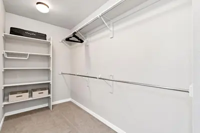 a walk in closet with white walls and shelves at Comet Haus Modern 3BR with Office and King Beds in Fort Collins