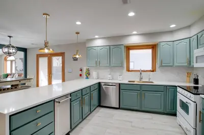 a kitchen with blue cabinets and white counter tops at Private Pool and Yard Spacious Brighton Home! in Brighton