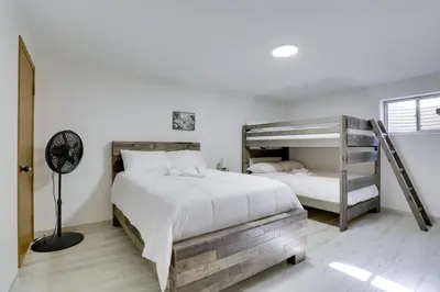 a bedroom with two bunk beds and a fan at Private Pool and Yard Spacious Brighton Home! in Brighton