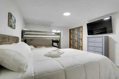 a bedroom with two beds and a flat screen tv at Private Pool and Yard Spacious Brighton Home! in Brighton