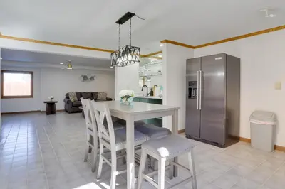 a kitchen and living room with a table and a refrigerator at 6 Mi to Barr Lake Apt with Yard and Pool Access! in Brighton