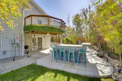 a house with a patio with blue stools at 6 Mi to Barr Lake Apt with Yard and Pool Access! in Brighton