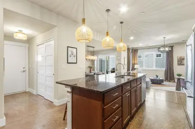 a kitchen with a large island with a sink at Ember and Ash Designer Home with King Beds, Games in Fort Collins