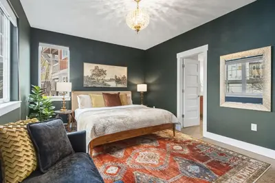 a bedroom with a bed and a couch at Ember and Ash Designer Home with King Beds, Games in Fort Collins