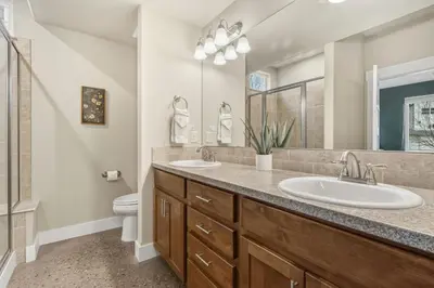 a bathroom with two sinks and a toilet at Ember and Ash Designer Home with King Beds, Games in Fort Collins