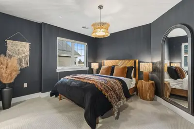 a bedroom with a bed and a large mirror at Ember and Ash Designer Home with King Beds, Games in Fort Collins