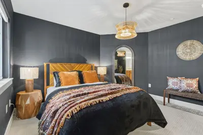 a bedroom with a large bed with blue walls at Ember and Ash Designer Home with King Beds, Games in Fort Collins
