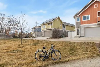 a bike parked in the grass in front of a house at Ember and Ash Designer Home with King Beds, Games in Fort Collins