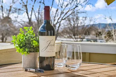 a bottle of wine and two glasses on a table at The Revive Loft with Balcony, Workspace and Bikes in Fort Collins