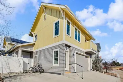 a yellow and white house with bikes parked in front at The Revive Loft with Balcony, Workspace and Bikes in Fort Collins