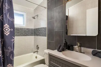 a bathroom with a sink and a toilet and a tub at The Wild Western - 5Bed, Hot Tub, Sauna, Mini Putt, Fire Pit in Denver