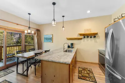 a kitchen with a table and a refrigerator at Seasons at Keystone 1841 in Keystone