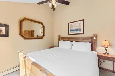 a bedroom with a white bed and a mirror at Seasons at Keystone 1841 in Keystone