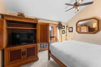 a bedroom with a bed and a flat screen tv at Seasons at Keystone 1841 in Keystone