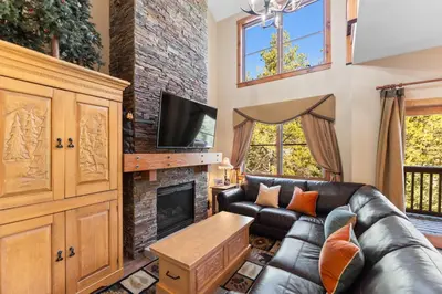 a living room with a leather couch and a fireplace at Seasons at Keystone 1841 in Keystone