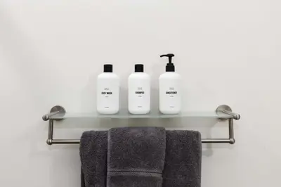 a bathroom with three bottles of soap and towels on a shelf at Union Station downtown and gameday retreat! in Denver