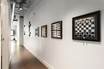 a hallway with paintings on a wall with a chessboard at Union Station downtown and gameday retreat! in Denver