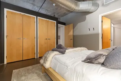 a bedroom with a large white bed with wooden cabinets at Union Station downtown and gameday retreat! in Denver