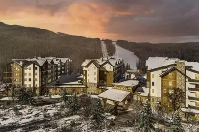 a group of buildings with snow on the ground at Kindred Resort Luxury Ski In, Ski Out 2 Bedroom Residence At The River Run Gondola in Dillon