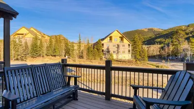 two blue benches sitting on a deck with a view at Fireplace Game Room Mountain Views Near Golf Dining Keystone River Run by AvantStay in Dillon