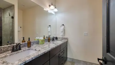 a bathroom with two sinks and a large mirror at Fireplace Game Room Mountain Views Near Golf Dining Keystone River Run by AvantStay in Dillon