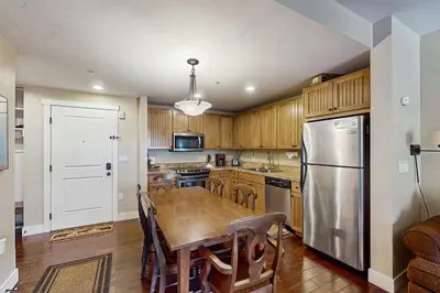 a kitchen with a table and a stainless steel refrigerator at Base Camp One 413 in Granby
