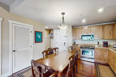 a kitchen with a wooden table and a dining room at Base Camp One 413 in Granby