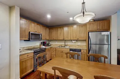 a kitchen with wooden cabinets and a wooden table at Base Camp One 413 in Granby