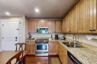 a kitchen with wooden cabinets and a sink and a stove at Base Camp One 413 in Granby