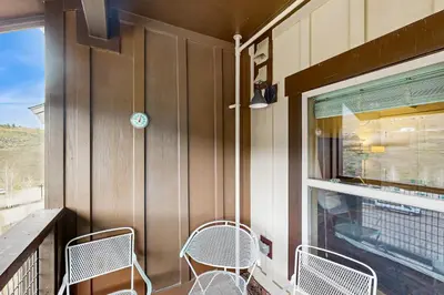 two chairs sitting on a porch with a window at Base Camp One 413 in Granby
