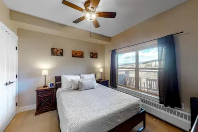 a bedroom with a bed with a ceiling fan and a window at Base Camp One 314 in Granby
