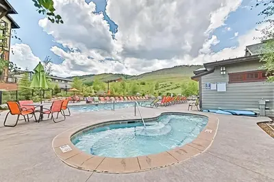 a pool with chairs and a table and a building at Base Camp One 314 in Granby
