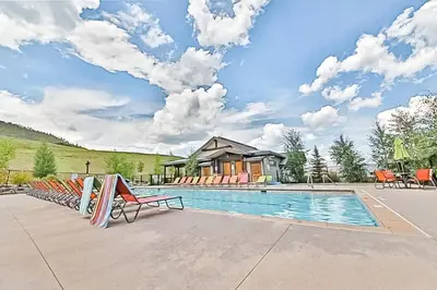 a swimming pool with chairs and a house at Base Camp One 314 in Granby