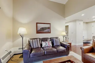 a living room with a brown leather couch at Base Camp One 403 in Granby
