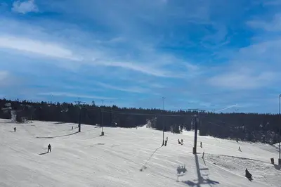 a group of people skiing down a snow covered slope at Base Camp One 403 in Granby