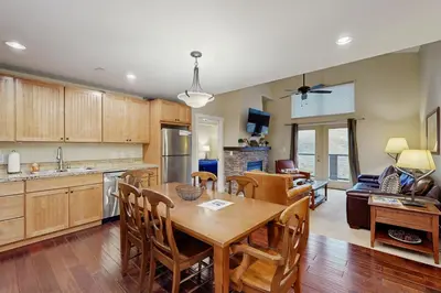 a kitchen and living room with a wooden table and chairs at Base Camp One 403 in Granby