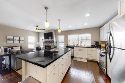 a kitchen with white cabinets and a black counter top at Base Camp One 316 in Granby