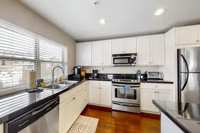 a kitchen with white cabinets and stainless steel appliances at Base Camp One 316 in Granby