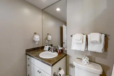 a bathroom with a sink and a toilet and a mirror at Base Camp One 316 in Granby