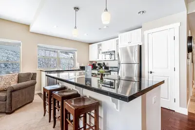 a kitchen with a black counter top and a refrigerator at Base Camp One 201 in Granby