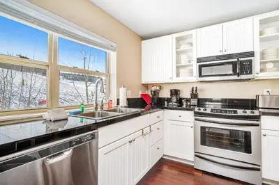 a kitchen with white cabinets and a large window at Base Camp One 201 in Granby
