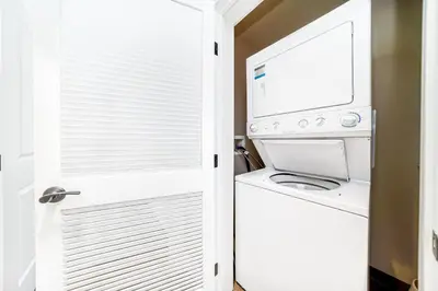 a laundry room with a washer and dryer next to a door at Base Camp One 201 in Granby