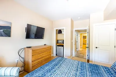 a bedroom with a bed and a flat screen tv at Base Camp One Penthouse 416C in Granby