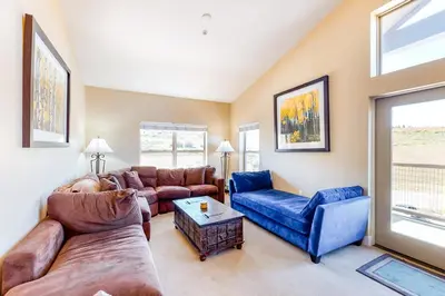 a living room with a couch and a table at Base Camp One Penthouse 416C in Granby