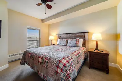 a bedroom with a bed and two lamps and a window at Base Camp One 412 in Granby