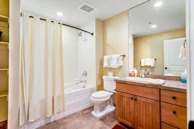 a bathroom with a toilet and a tub and a sink at Base Camp One 412 in Granby
